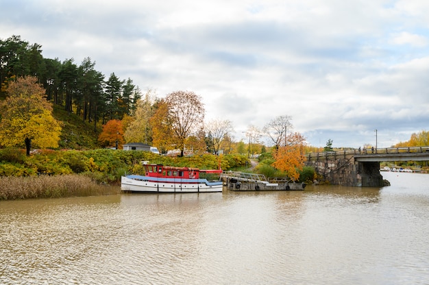 Piroscafo, longboat sul molo. paesaggio autunnale.