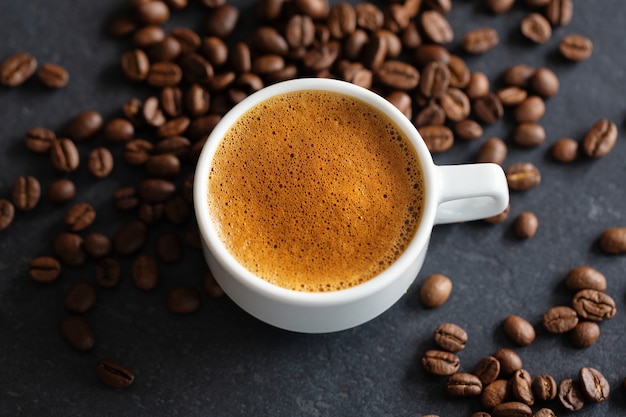 Steaming espresso cup on grey background. Closeup