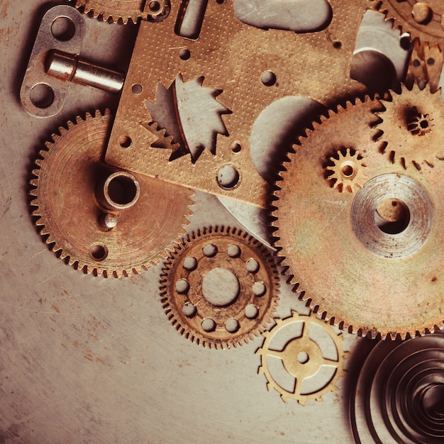 Steampunk background from mechanical clocks details over old metal background. Inside the clock, gears