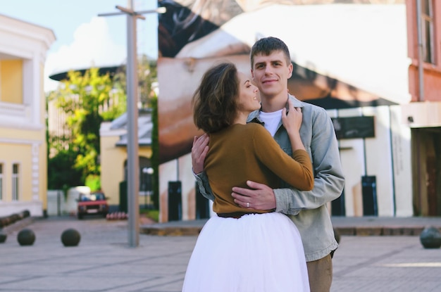 Stedelijk liefdesverhaal. jonge man in een overhemd. Aantrekkelijke vrouw in jurk. Paar wandelen. Datum. Trouwdag