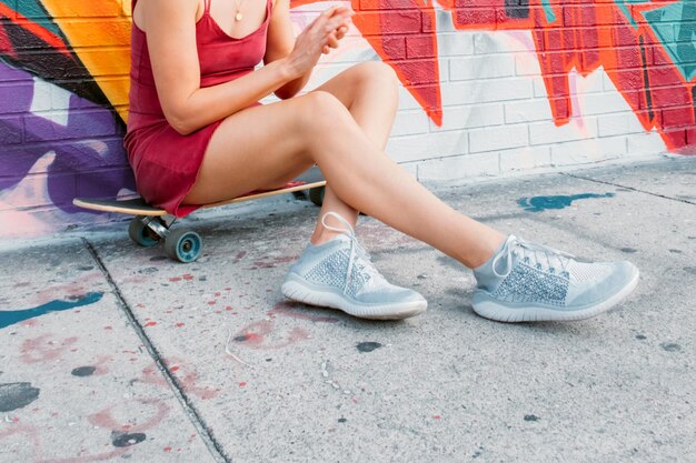 Foto stedelijk portret van jonge vrouw met skateboard kleurrijke straatkunst