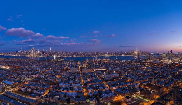 Stedelijk stadsgezicht van Lower Manhattan, Jersey City en Hudson River. New York in de avondschemering. Luchtfoto. De Verenigde Staten van Amerika.