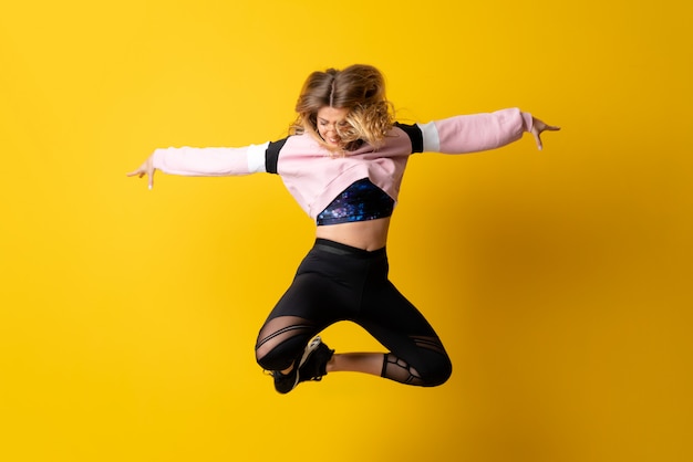 Stedelijke Ballerina die over geïsoleerd geel dansen en springen
