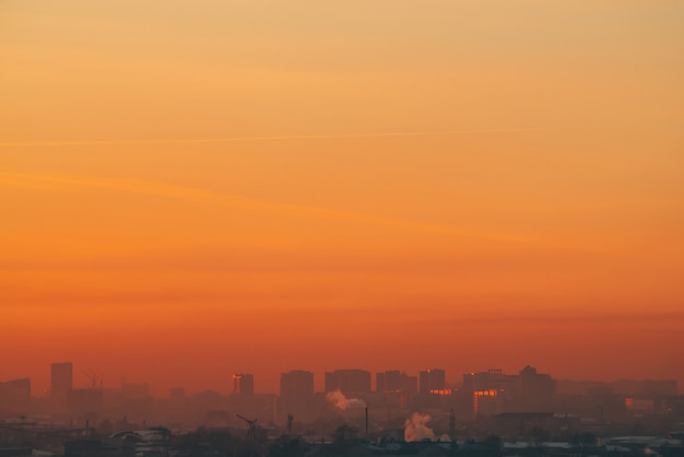 Stedelijke hoogbouw achter privé huizen op zonsondergang.