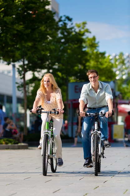 Stedelijke paar berijdende fiets in vrije tijd in stad