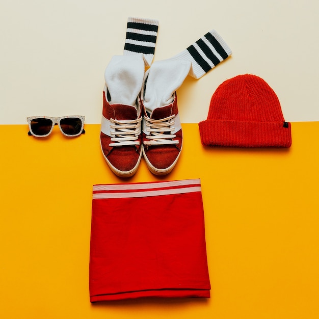 Stedelijke stijl kleding. Skateboard mode-outfit. Sneakers, kousen, hoed. Focus op rood