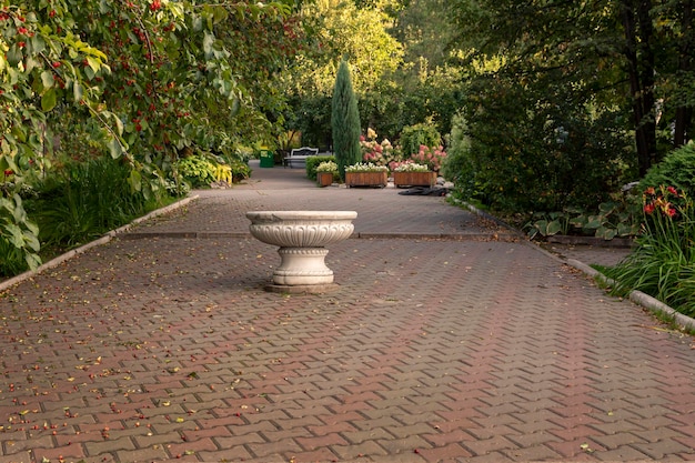 Steegje in een zomers park met siervazen Landscaping vaste planten