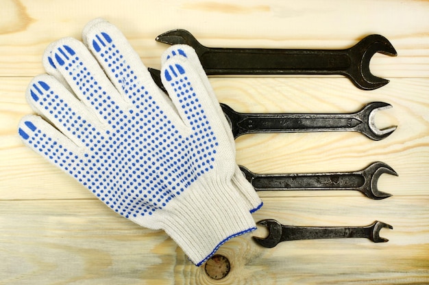 Steeksleutels en beschermende handschoenen op houten tafel