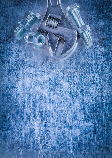 Фото Стальные разводные гаечные гайки и болты с резьбой на поцарапанном металлическом фоне копируют концепцию построения космического изображения