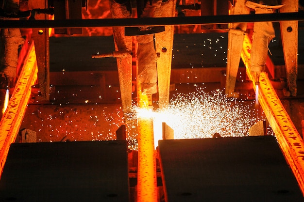 Foto billette in acciaio al taglio a fiamma in impianto metallurgico. produzione metallurgica, industria pesante, ingegneria, produzione di acciaio.