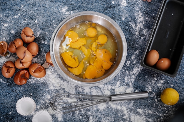 Steel bowl with eggs on a blue table