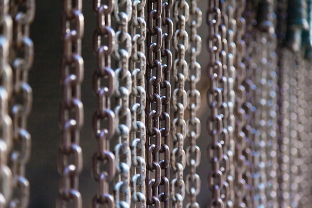 Steel chains directly hang on a dark background closeup