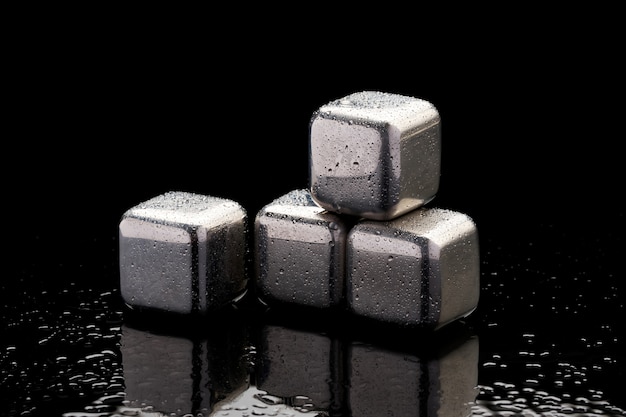 Steel cooling cubes for cocktail drink on glass background