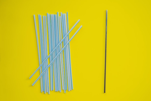 Steel drinking vs disposable straws on a yellow background zero waste concept