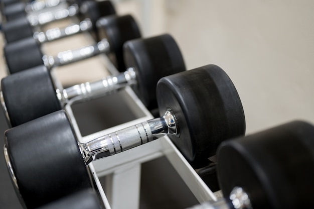 Steel dumbbells placed on the floor at the gym.