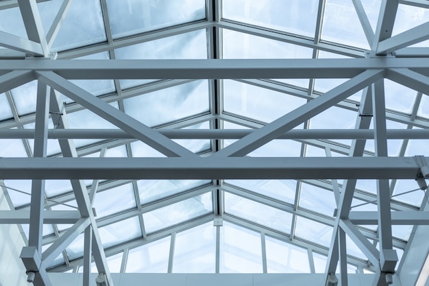 Steel frame of glazed roof of warehouse ceilings are made of metal beams interconnected by welding