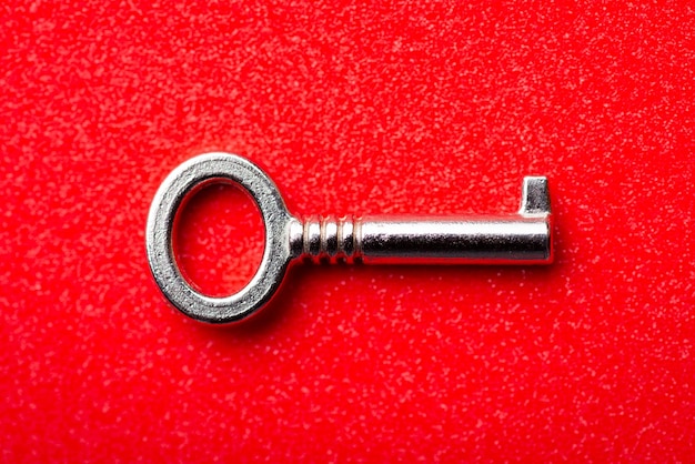 Steel key on red background