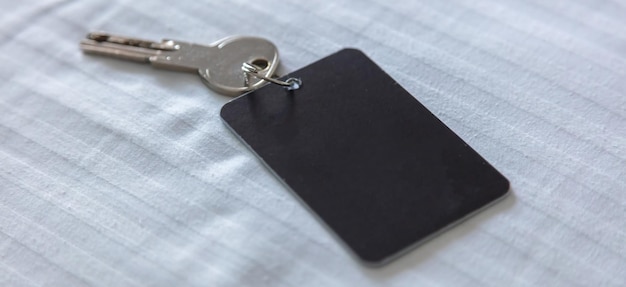 Steel key ring with blank label for text or number and hotel\
room door key closeup