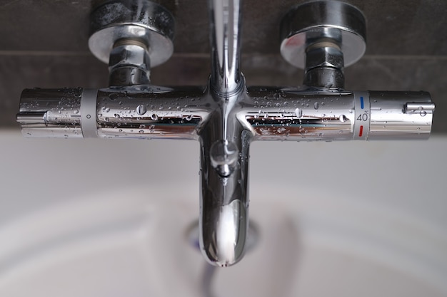 Steel mixer with a temperature sensor in the bathroom closeup