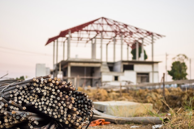 Photo steel rebar for reinforcement concrete at construction site with house under construction