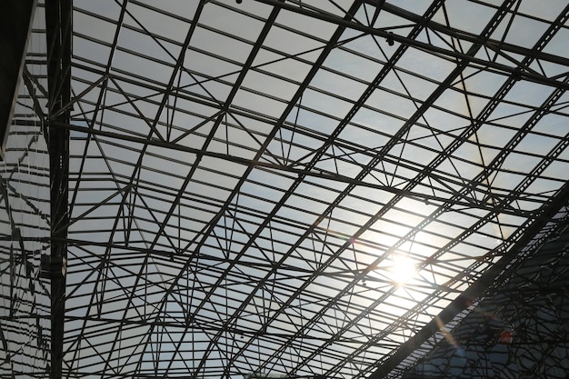 A steel roof structure of an indoor stadium with steel beams interlaced in the air