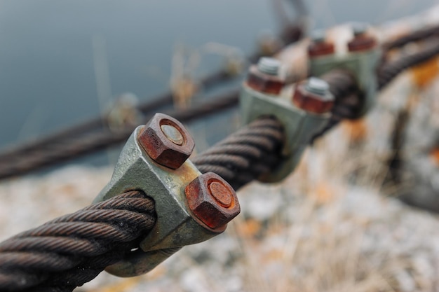 Steel Rope Clip with rusty nuts on steel cables