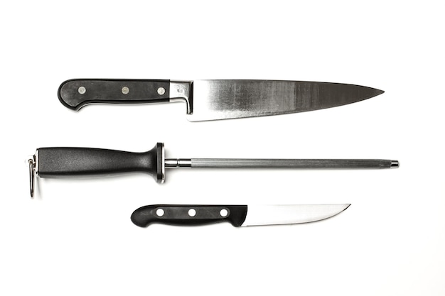 Стальная точилка и кухонные ножи, изолированные на белом фоне