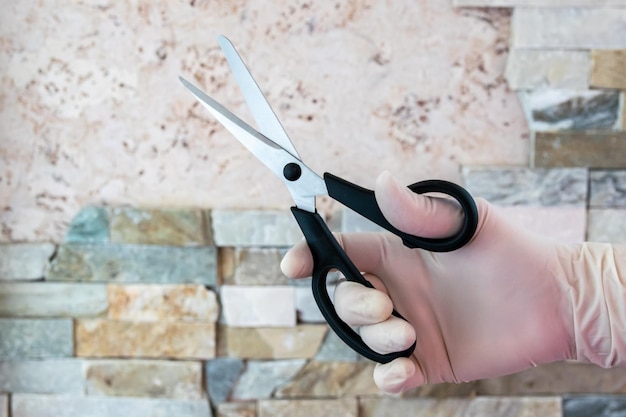 Steel shears in the hand with rubber glove