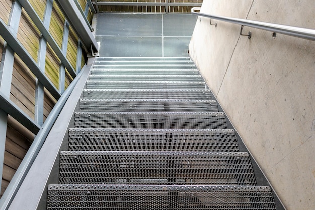 A steel staircase with a metal handrail and a sign that says'the word'on it '