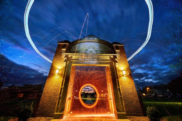 Steel wool and drone lights at dusk around park with old school archway