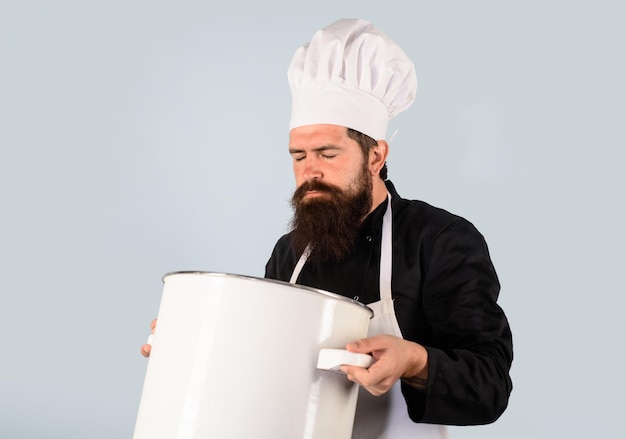 Steelpan braadpan kok man in schort houdt steelpan in keuken kookpot kookgerei servies