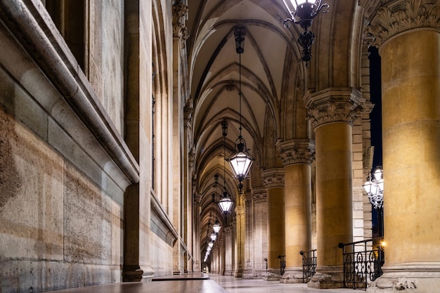 Steen gebogen perspectief met oude kolommen en gewelfd plafond met hangende oude lampen in de tempel in Wenen, Oostenrijk.