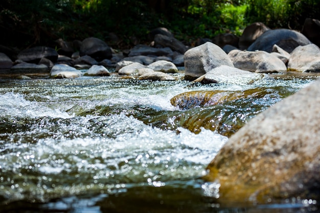 Steen met waterstroomversnelling op de rivier