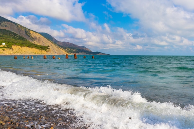 Foto steenachtig strand van de kust van de zwarte zee in het dorp bolsjoj, utris vol met mensen op een heldere zonnige zomer