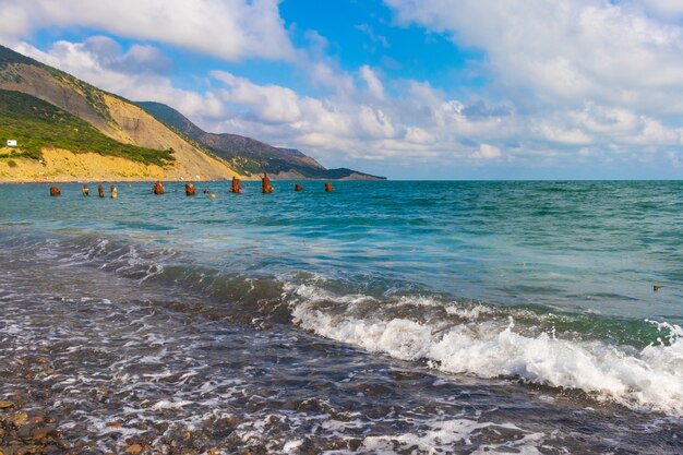 steenachtig strand van de kust van de Zwarte Zee in het dorp Bolsjoj, Utris vol met mensen op een heldere zonnige zomer