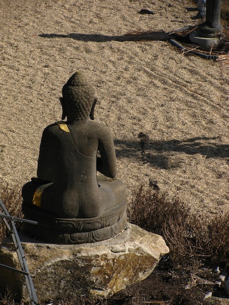 Foto steenboeddha tegen zand.