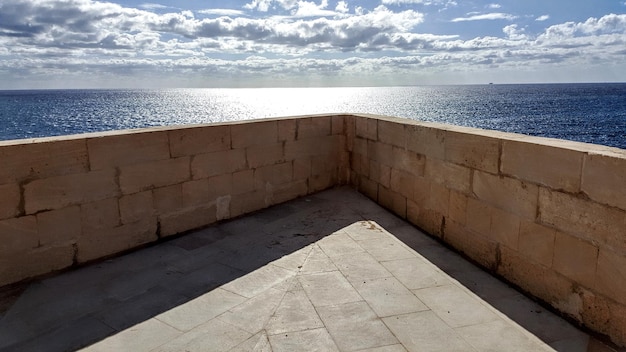 Foto steenmuur bij de zee tegen de lucht