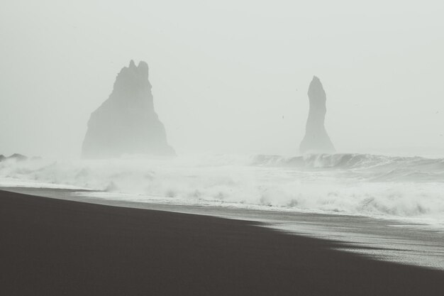 Steep rocks in ocean waves monochrome landscape photo