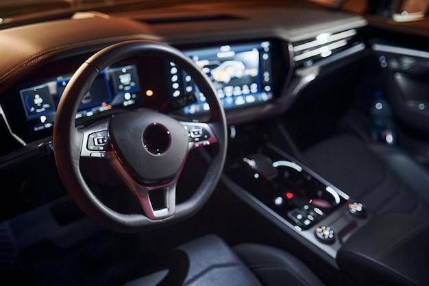 Steering wheel and navigation display Close up view of front park of new modern black automobile