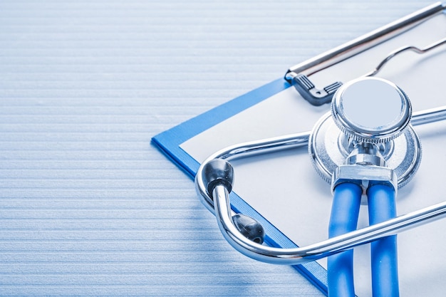 Stehoscope and clipboard on blue background medical concept