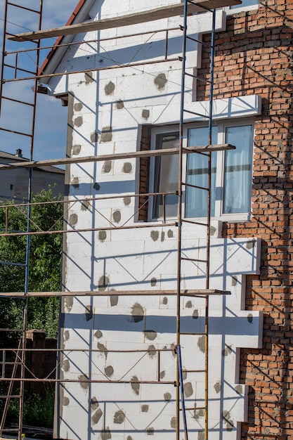 Steiger op huisrenovatie Huis voor renovatie met de steiger voor werknemers bij het bouwen