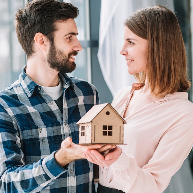 Stel met mooi stuk speelgoed huis bekijkend elkaar