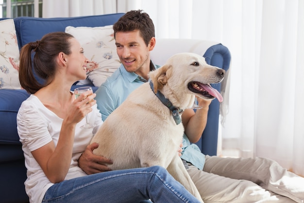 Stel met wijnglas en huisdierenhond in woonkamer