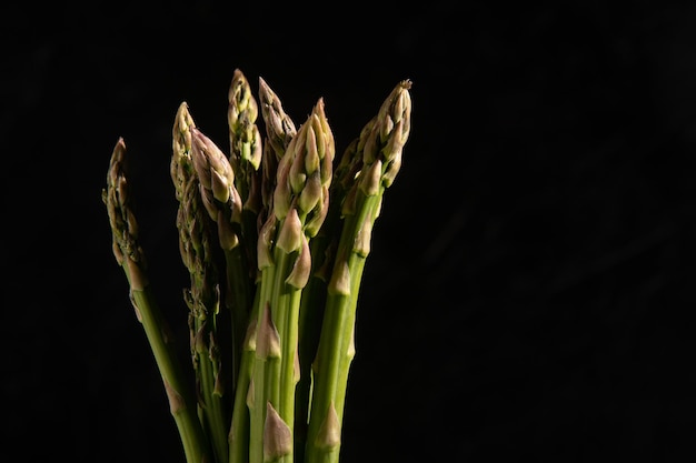 Stelletje asperges geïsoleerd op zwarte achtergrond horizontaal