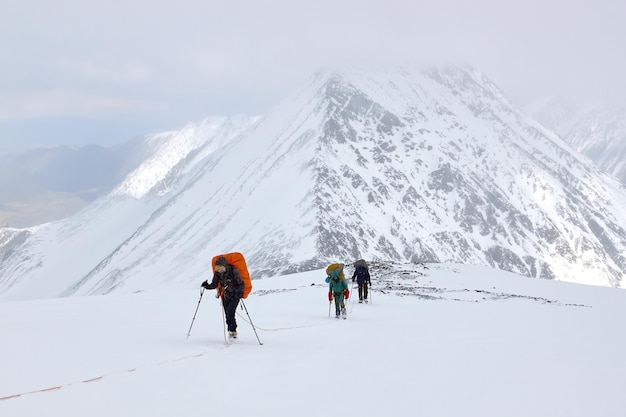 Stelletje bergbeklimmers klimt naar de top van een met sneeuw bedekte berg