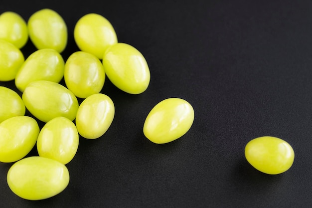 Stelletje groene druiven geïsoleerd op de zwarte achtergrond