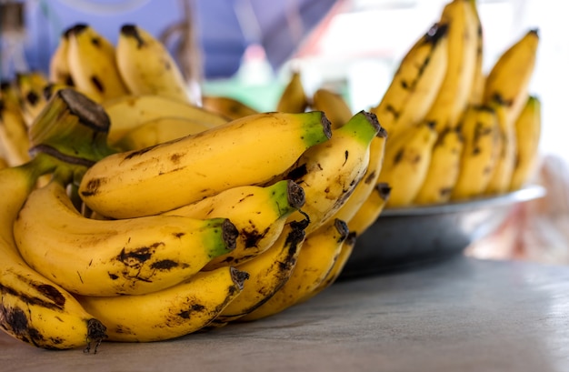 Stelletje heerlijke rijpe gele bananen close-up op een houten bord met selectieve focus