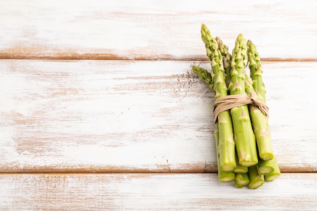 Stelletje verse groene asperges op witte houten achtergrond Zijaanzicht kopie ruimte