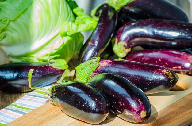 Stelletje verse paarse aubergines op een schoolbord