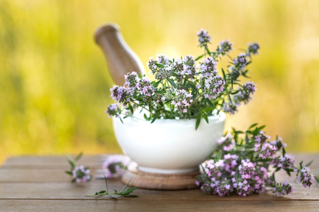 Stelletje verse tijm op een houten tafel tegen de achtergrond van de natuur. Kopieer ruimte